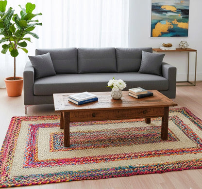 Living room with a gray sofa, wooden coffee table, and colorful rug.